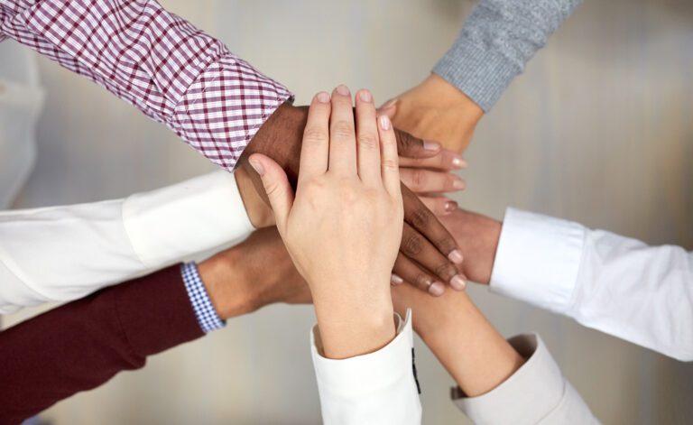 business team with hands on top at office